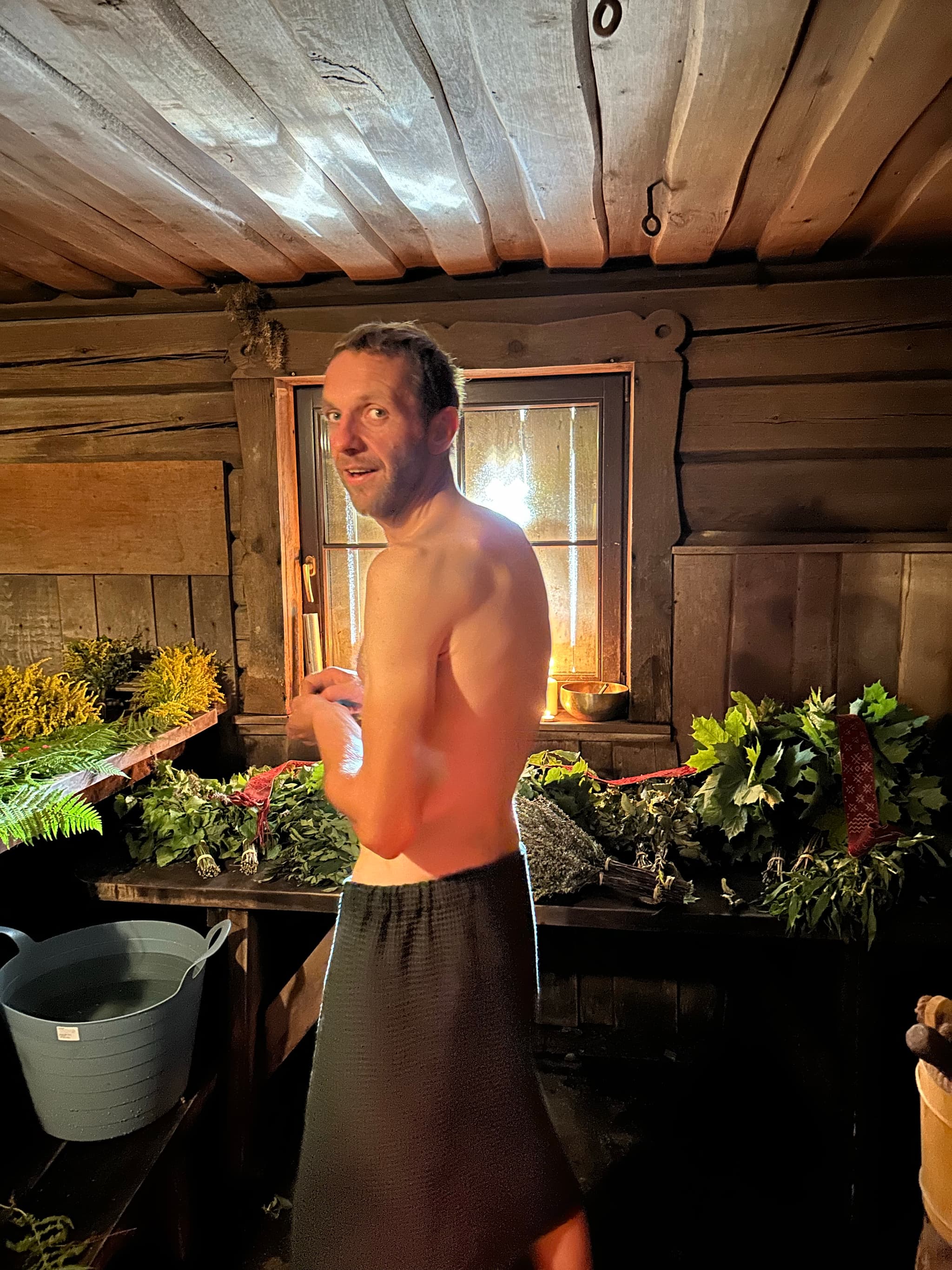 Matīss Vilde holding a sauna whisk in the steam-filled sauna at Lielzemenes